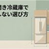 観音開き冷蔵庫の前で男性が設置幅や開閉スペースを確認している、失敗しない冷蔵庫選びを表したアイキャッチ画像。
