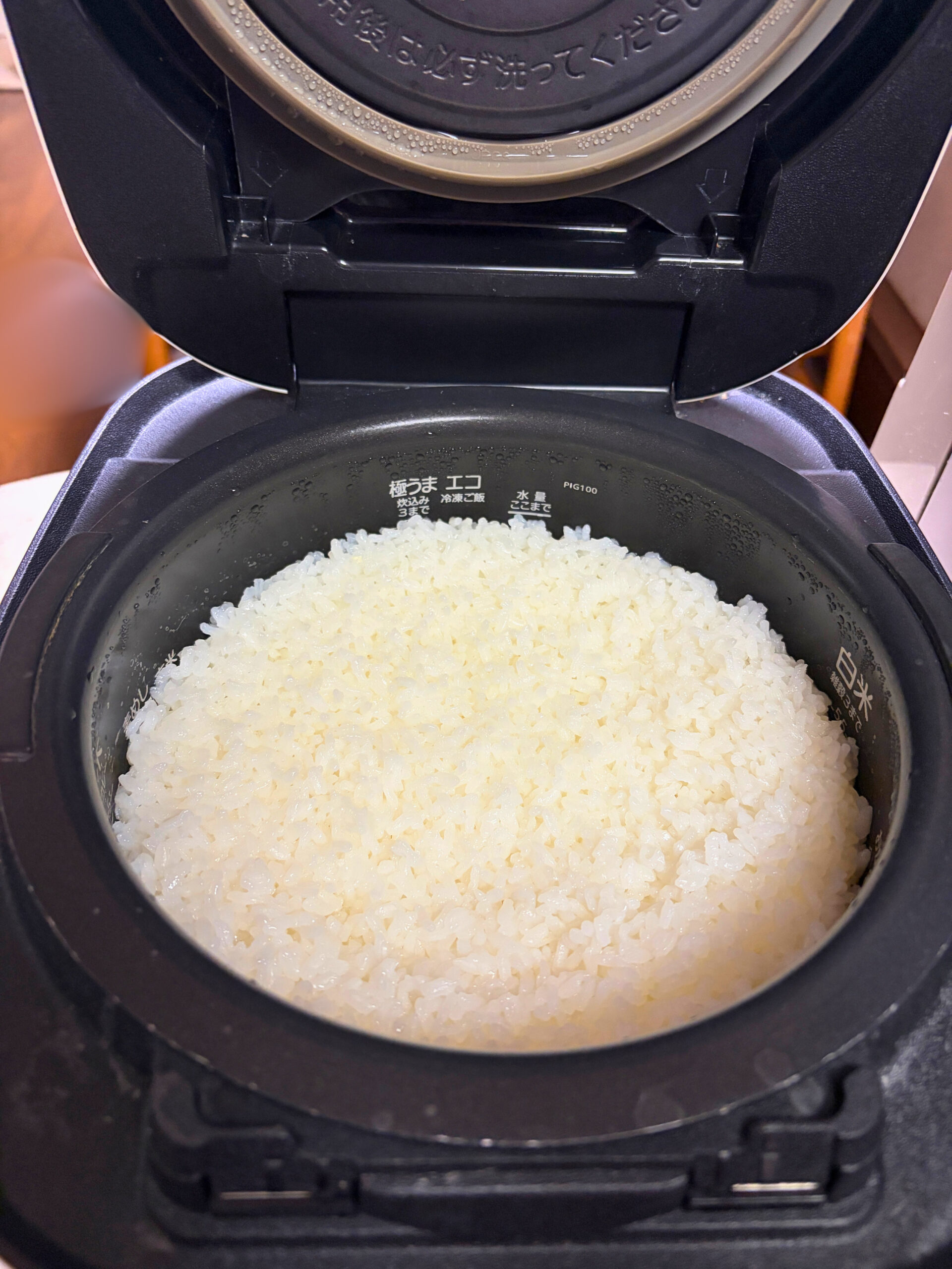 ふたを開けた炊飯器の内釜に、つやのある白米が炊き上がっている様子