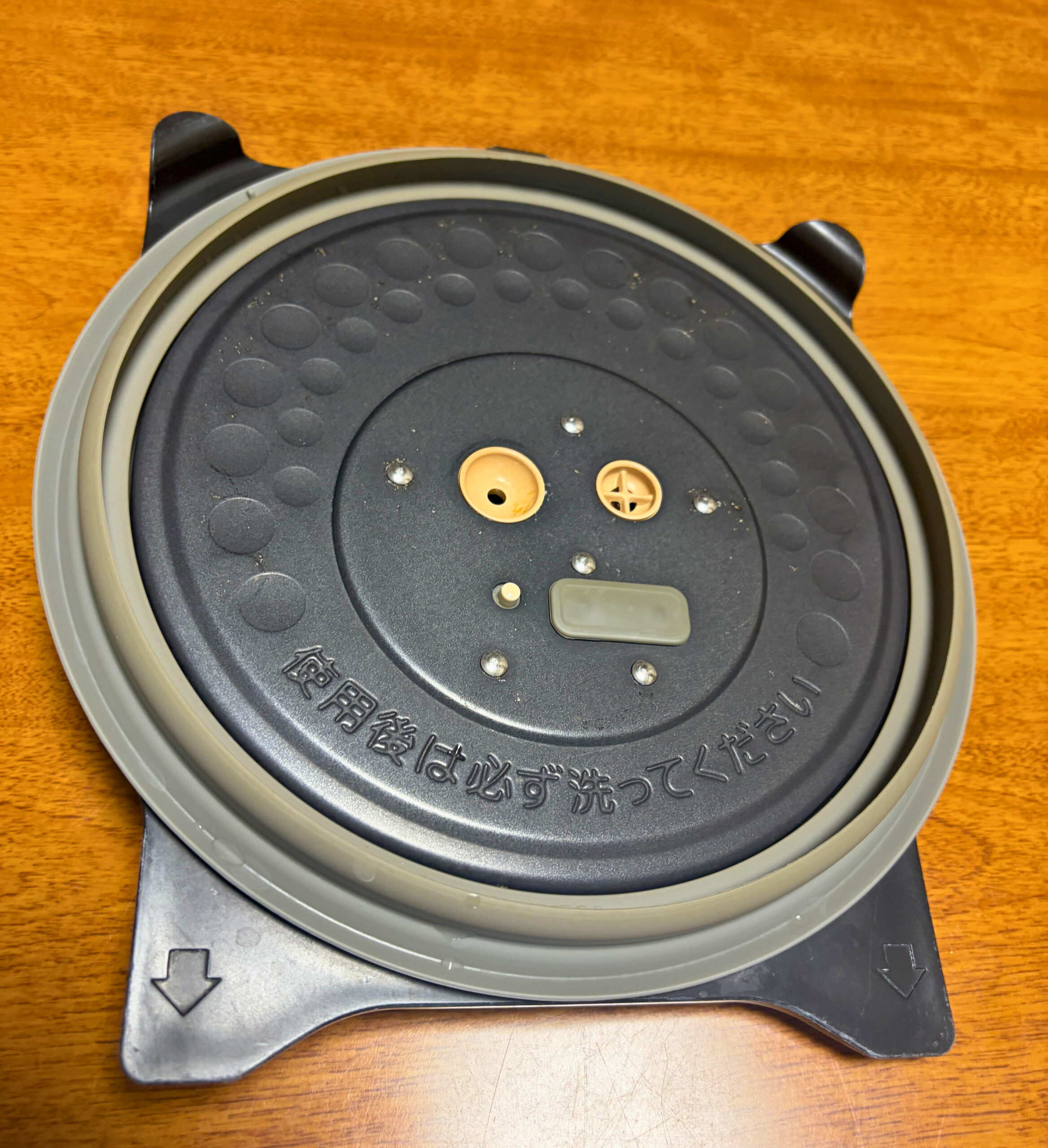 炊飯器から取り外した内ぶたをテーブルに置き、周囲のパッキンと中央の部品が見えている様子
