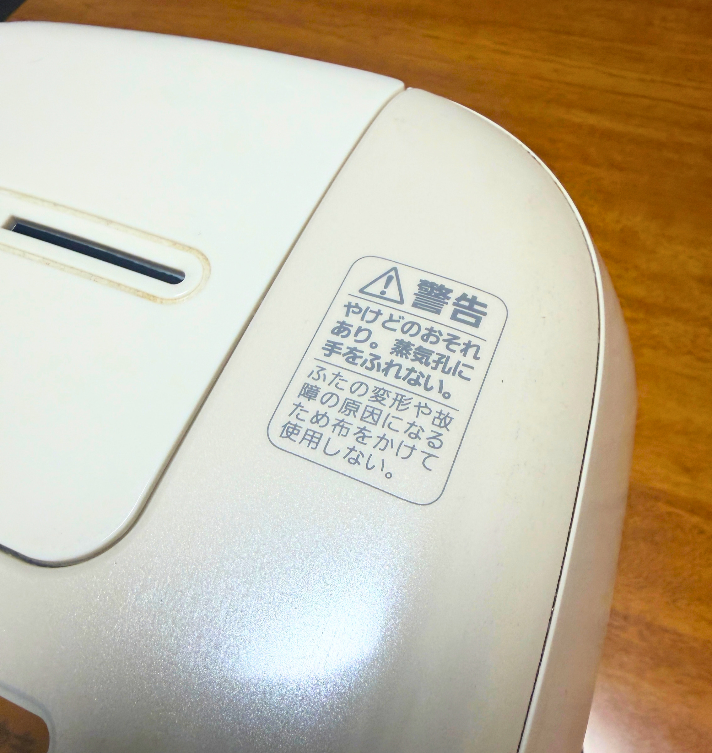 炊飯器のふた上部にある蒸気口とやけどに関する警告表示を拡大した様子